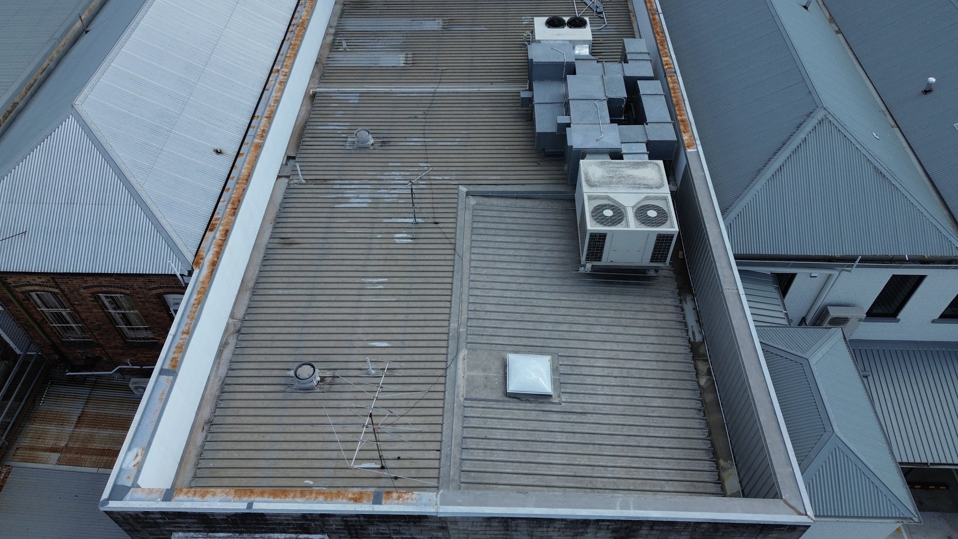 Professional drone conducting roof inspection at dawn